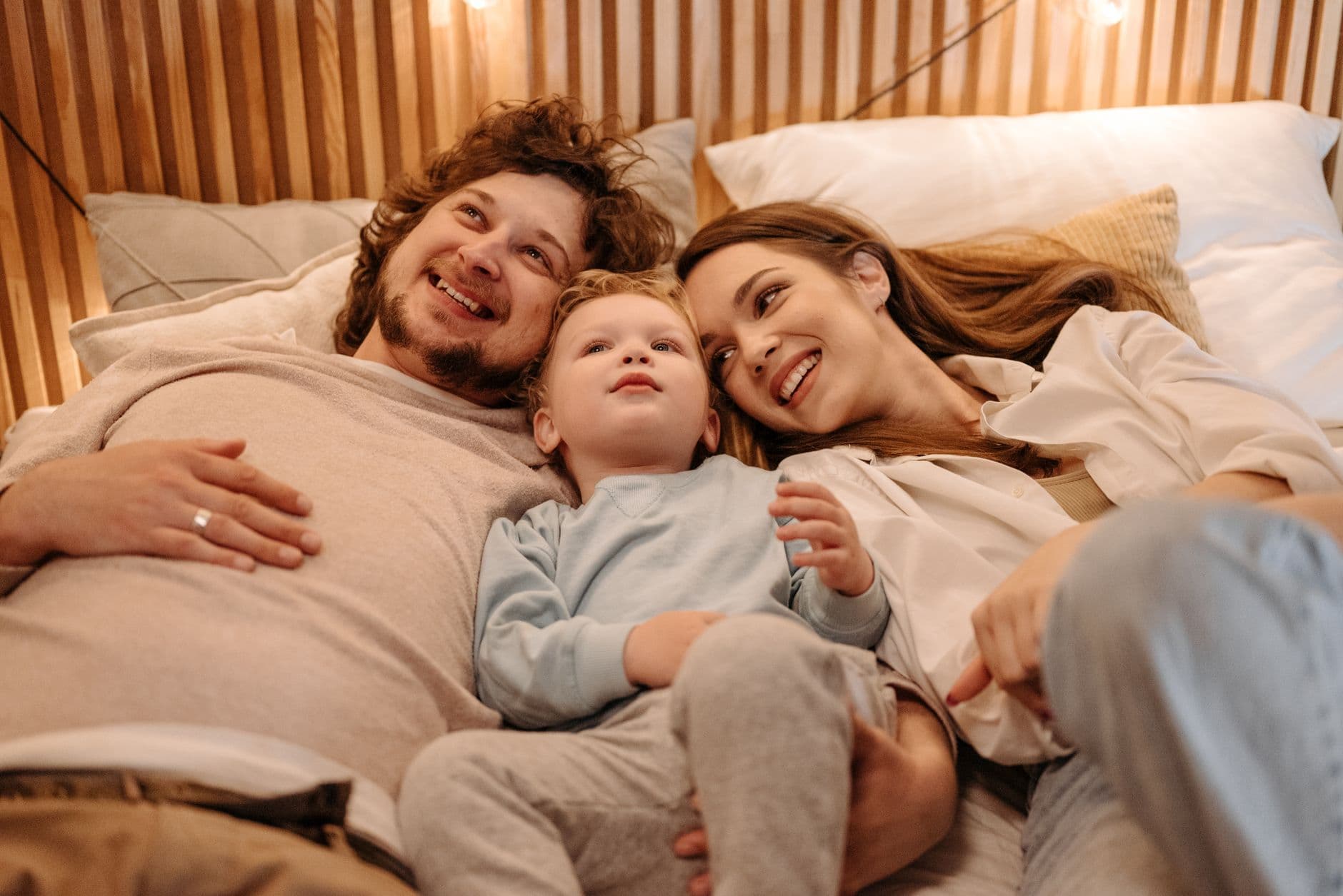 A joyful family bonding together while lying in bed, creating precious moments.